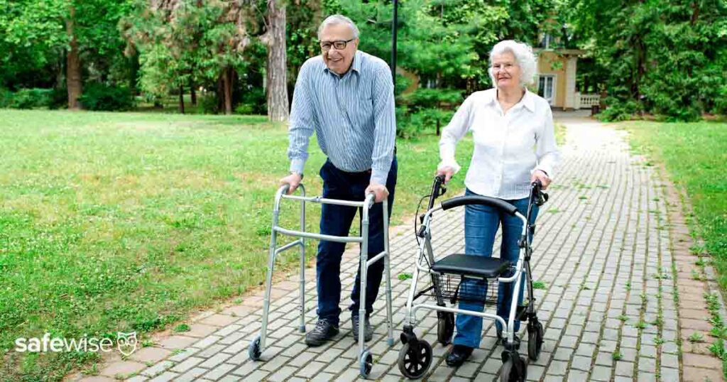 two seniors walking with walkers outdoors 1